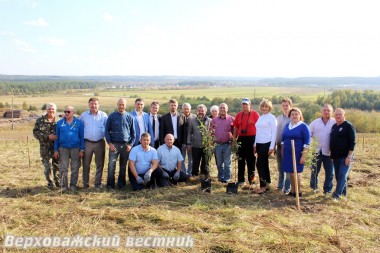 Хозяева и гости Сметанина перед посадкой сада на фоне вида на село